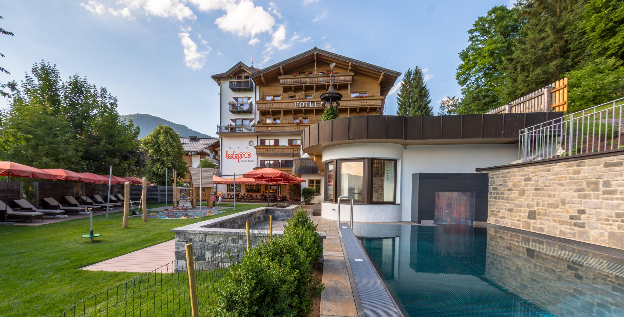 Außenansicht des Babyhotel und Kinderhotel Babymio mit Außenpool und Gartenbereich