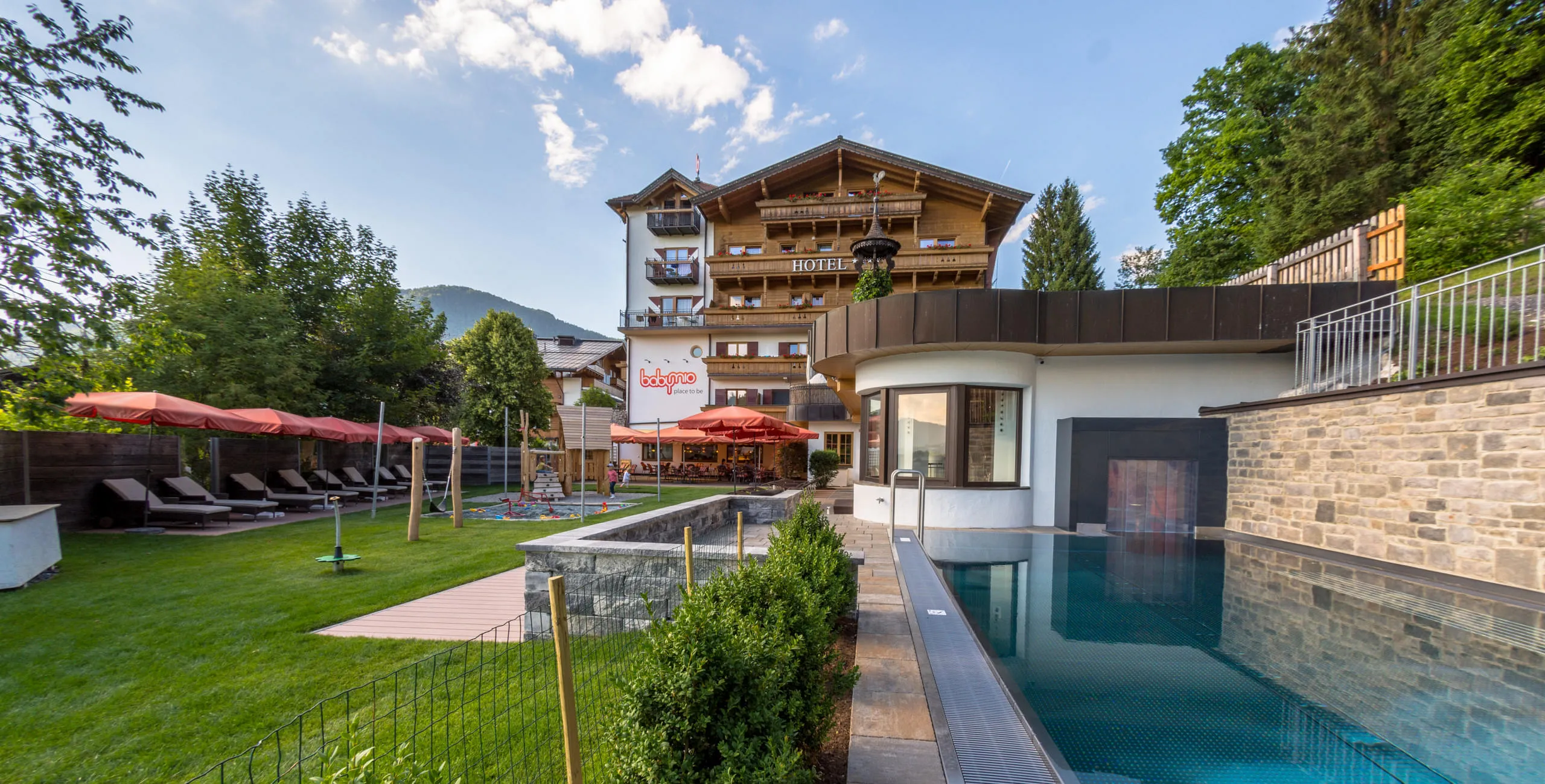 Außenansicht des Babyhotel und Kinderhotel Babymio mit Außenpool und Gartenbereich