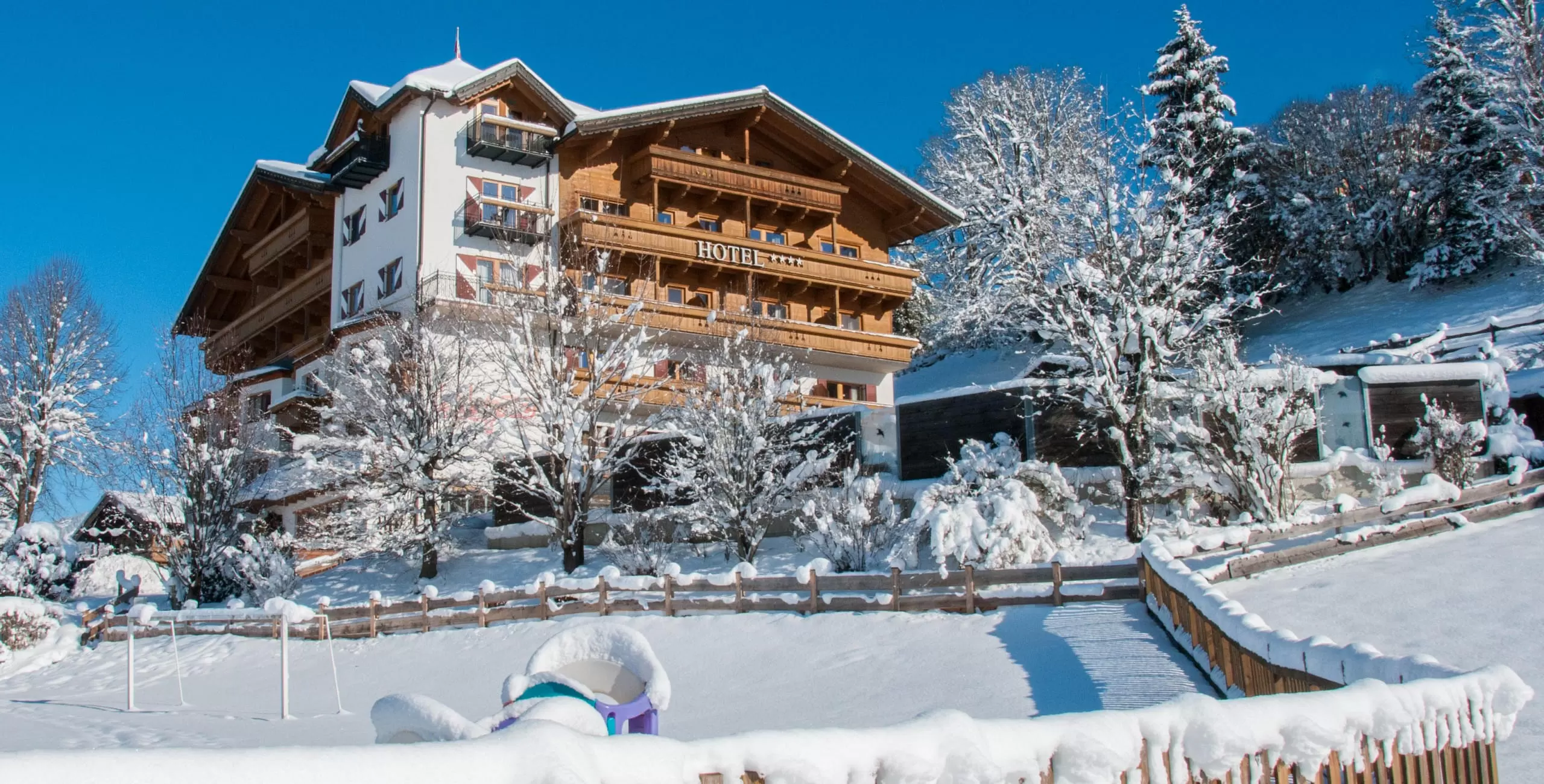 Außenansicht des Babyhotel und Kinderhotel Babymio mit Außenpool und Gartenbereich