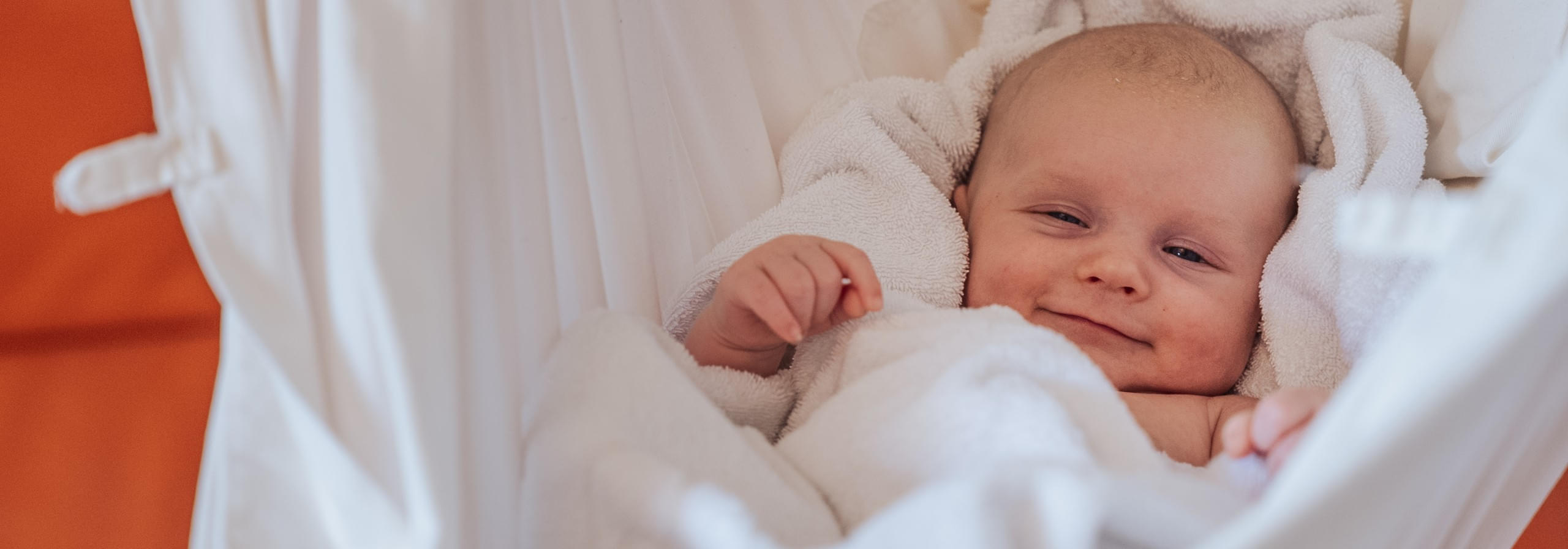Lächelndes Baby in einer Hängematte im Familienhotel Babymio