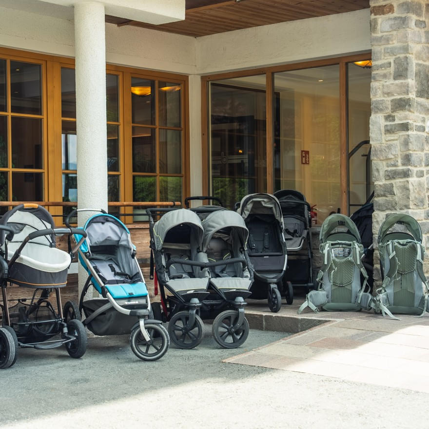 Reihe von Kinderwagen vor dem Hotel Babymio in Tirol