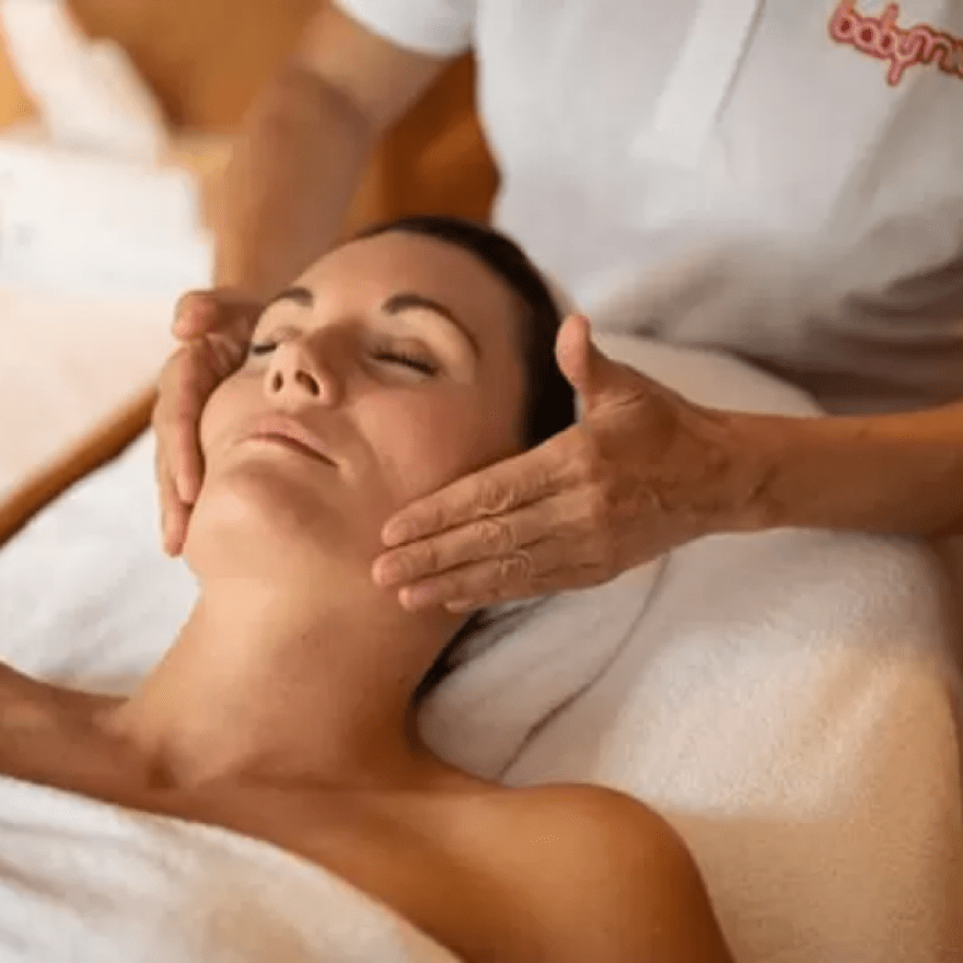 Frau genießt eine Gesichtsmassage im Hotel Babymio