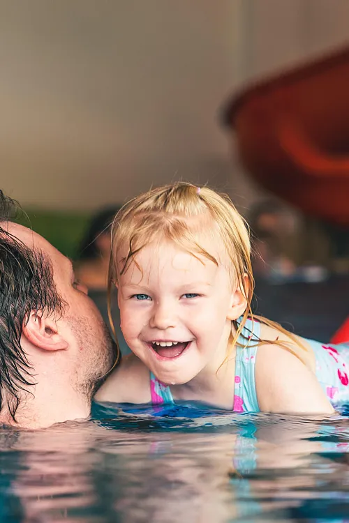 Kleinkind spielt auf einem blauen Hüpfpferd