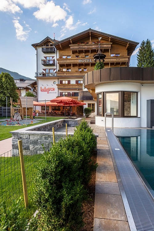 Außenansicht des Babyhotel und Kinderhotel Babymio mit Außenpool, Gartenbereich und Spielplatz