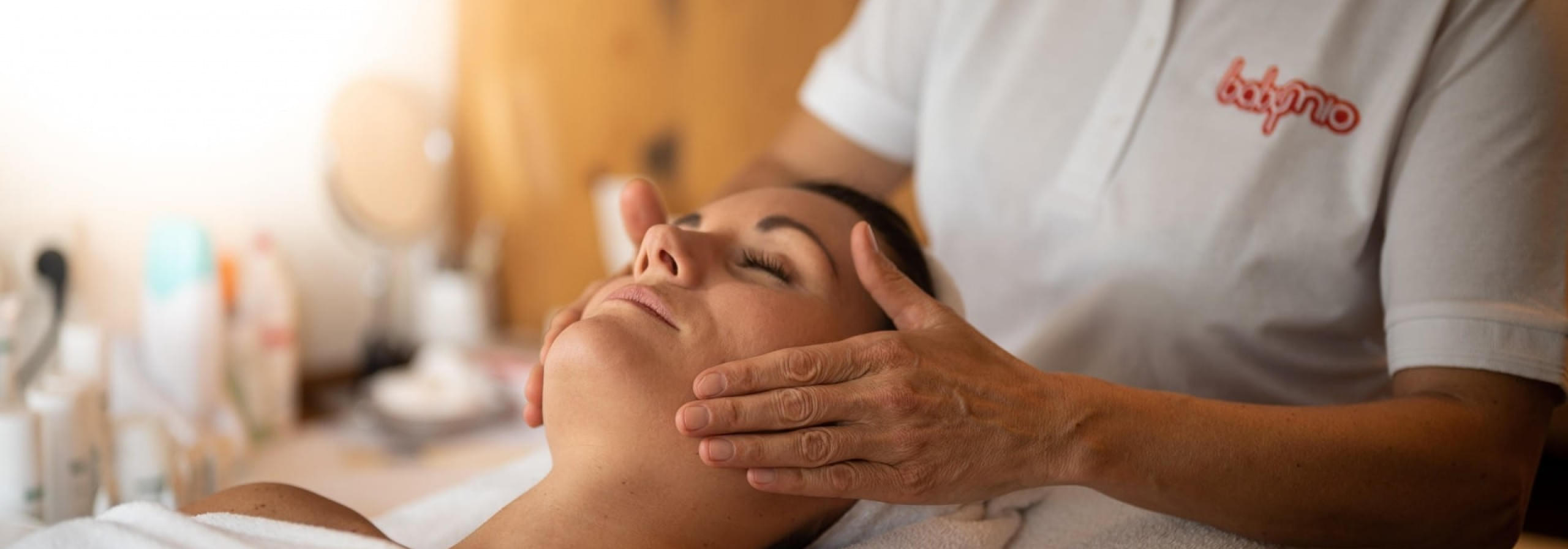 Frau erhält entspannende Gesichtsmassage im Spa-Bereich