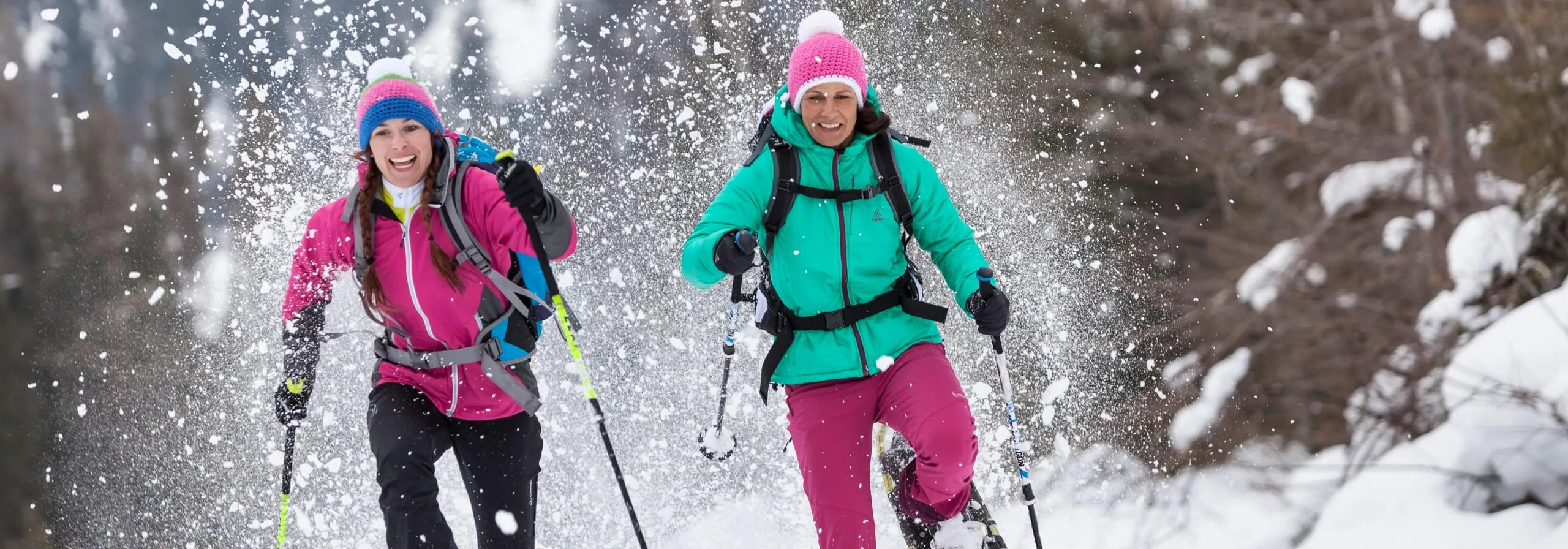 Zwei Frauen bei einer Schneeschuhwanderung im verschneiten Tiroler Winterwald