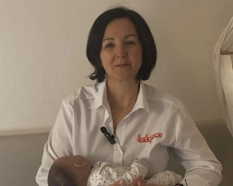 Mutter probiert Baby schwimmen zu lernen im Hallenschwimmbad des Hotel Babymio