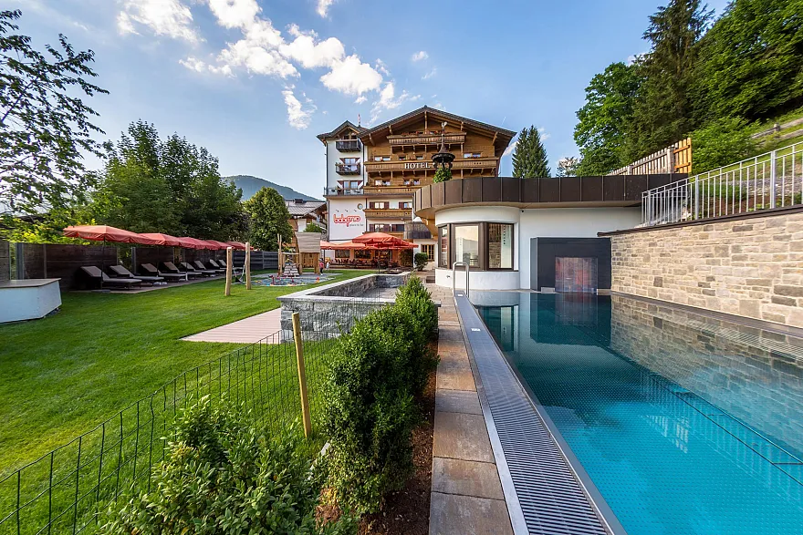 Außenansicht des Babyhotel und Kinderhotel Babymio mit Außenpool,  Gartenbereich und Spielplatz